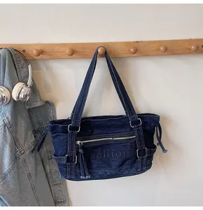 Détail du sac cabas en denim bleu foncé avec broderie fashion et garnitures en métal argenté