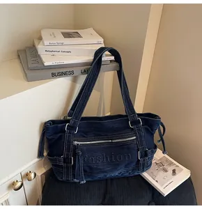 Détail du sac fourre-tout en denim bleu foncé avec logo Fashion et boucles argentées