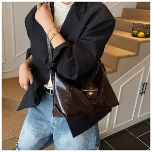 Close-up of vintage dark brown tote bag with crescent gold buckle on a stylish staircase