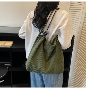 Detail of dark green corduroy tote bag with black and white checkered rope strap