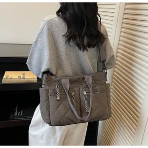 Detailansicht der grauen gesteppten Nylontasche mit Multi-Pocket-Design und Gurt