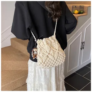Detail of hand-woven cream bucket bag with 3D diamond pattern and cute doll charm