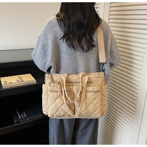 Detailed back view of a beige quilted nylon tote bag with multi-pocket functional design