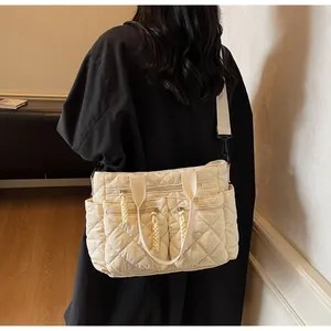 Detail einer beigen gesteppten Nylon-Tragetasche mit vielen Taschen und breitem Gurt