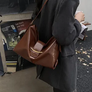 Retro caramel brown glossy leather underarm tote bag with golden metal buckle clasp