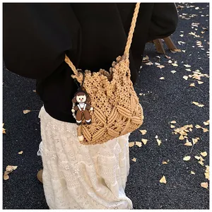 Detail of hand-woven crossbody bucket bag with cartoon charm and intricate patterns