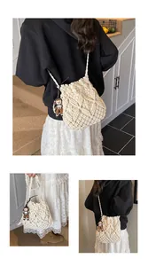 Detail of white macrame bucket bag with diamond weave pattern and cute doll charm