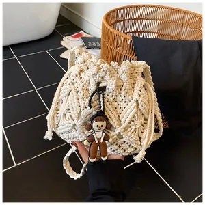 Detail of hand-woven cream bucket bag featuring intricate 3D floral patterns and a cute charm