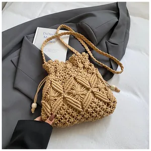 Detail of woven bucket bag featuring intricate patterns and drawstring with white beads