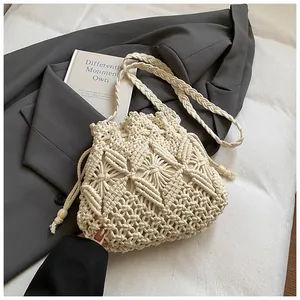 Detailed close-up of ivory woven bucket bag featuring drawstring and intricate patterns