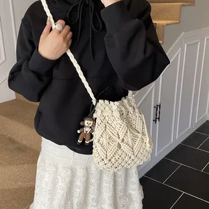 White macrame bucket bag with geometric patterns and a cute doll pendant for women