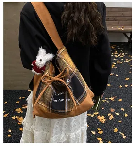 Close-up of vintage plaid tote bag with plush rabbit charm and autumn outdoor setting