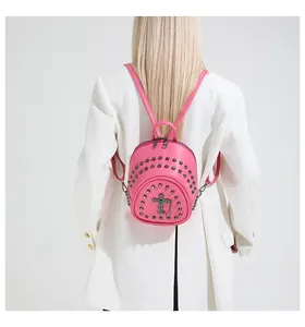Detail of rose red mini backpack with gothic cross pendant and black metal rivets