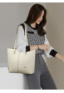 Close-up of litchi grain texture and gold logo on off-white tote bag for women