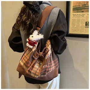 Retro brown plaid canvas tote bag with cute plush bunny charm shown on model back