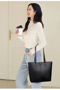 Chic black lychee grain leather tote bag worn by a model in a minimalist lifestyle setting