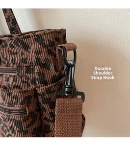 Detail of leopard print corduroy tote showing sturdy black metal swivel hook and strap