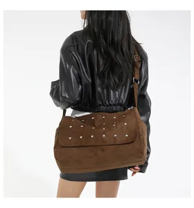 Détail de sac besace marron en similicuir suédé avec rivets porté par un mannequin