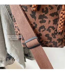 Detail of adjustable nylon shoulder strap and leopard print textured tote bag