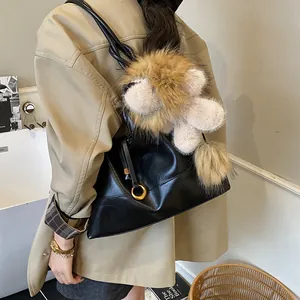 Retro black faux suede shoulder bag with gold hardware and large plush charm