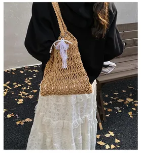 Detail der handgewebten Tasche mit Spitzenschleife, Perlen und herbstlichem Ginkgo