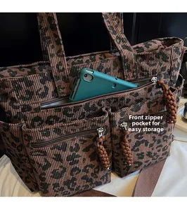 Detailed front zipper pocket of leopard print tote showing large tablet storage capacity