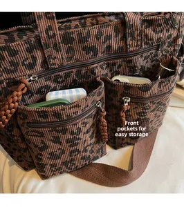 Detail view of front zip pockets on leopard print corduroy tote bag for easy storage