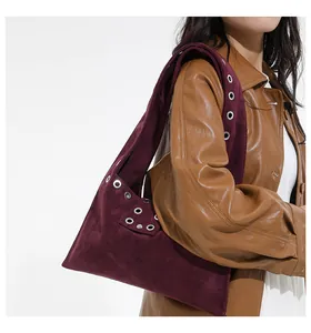 Detail of burgundy suede tote bag featuring silver rivet studs and wide shoulder strap