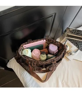 Spacious interior of leopard print tote bag holding a tablet, umbrella, and essentials