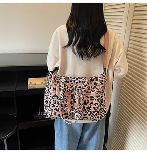 Close-up of pink leopard print corduroy tote bag featuring multiple functional zipper pockets