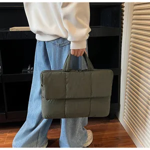Detail of olive green quilted laptop tote bag showing puffy texture and sturdy handles
