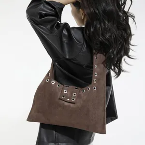 Dark brown faux suede shoulder bag with silver rivet trim shown on a model