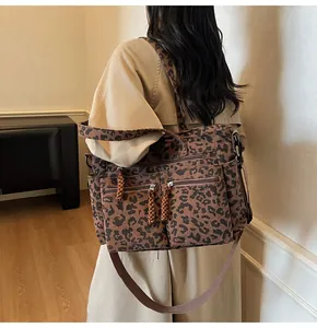 Detail view of corduroy leopard tote with dual front zippers on a stylish trench coat