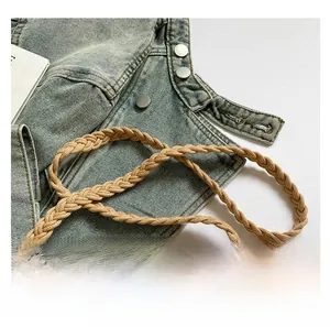 Detail of bohemian woven brown shoulder strap on washed blue denim background