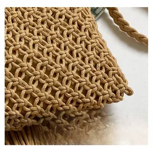 Detail shot of woven straw bag with hollow texture and bohemian tassel fringe