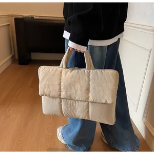 Detailed view of the quilted laptop bag featuring soft padded texture and top handle
