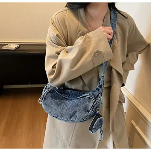 Makroaufnahme der gewaschenen Denim-Tasche mit kleinem runden Münzfach-Anhänger