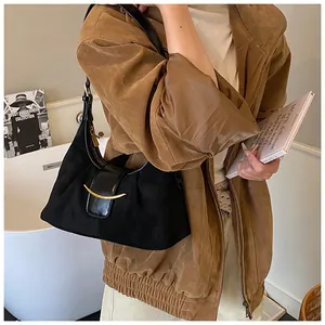 Détail d'un sac hobo noir mat avec une élégante boucle métallique dorée en forme de croissant