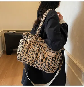 Close-up of leopard print corduroy tote bag featuring dual front zipper pockets and texture