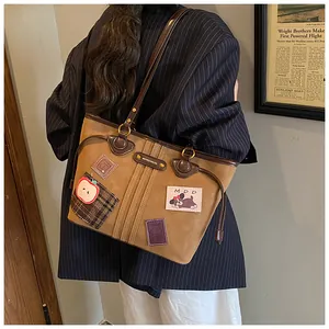 Détail du sac cabas marron vintage avec écussons de dessin animé et plaque logo