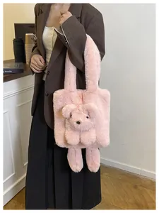Detail of pink plush tote bag with a 3D teddy bear charm shown in a lifestyle setting