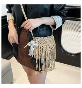 Detail of bohemian woven bag featuring macramé texture, long fringes, and pearl lace bow