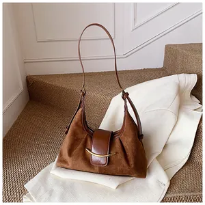 Détail du sac à bandoulière marron avec coutures en cuir mat et finitions dorées