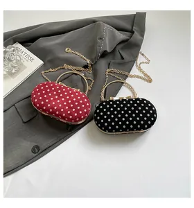 Close-up of red and black polka dot evening clutches with velvet texture and metal handles