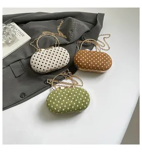 Detailed view of polka dot crossbody bags in ivory, brown, and green with chain straps