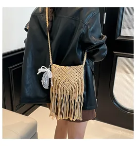 Detail of bohemian macramé crossbody bag with geometric weave and long fringe tassels