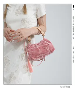 Detail of pink velvet handbag with bamboo handle and tassel paired with a cheongsam dress