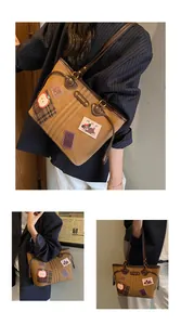 Détails d'un sac cabas vintage marron avec des patchs décoratifs de chien et du métal