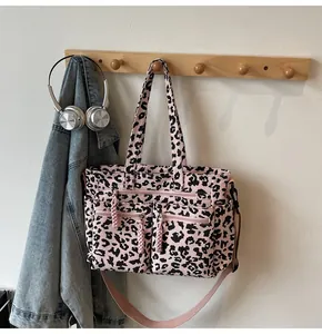 Detail of pink leopard print tote bag with multiple zip pockets and adjustable strap