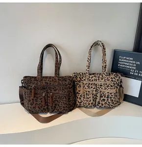 Detail of leopard print corduroy tote bags with multi-pocket zippers and braided pullers